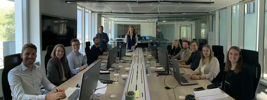 une équipe de collaborateurs souriants et motivés, travaillant ensemble de manière dynamique dans un bureau moderne et lumineux.